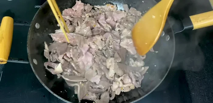 Cho tim heo và gan heo vào xào cùng, thêm 2 muỗng canh sốt xào.
