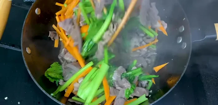 Cho cà rốt vào xào, thêm 2 muỗng canh sốt xào.