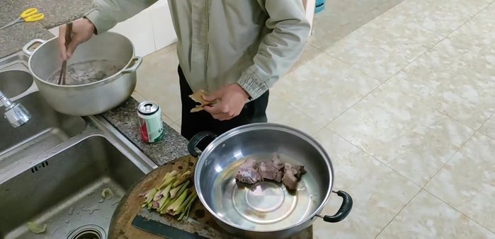 Đun nước sôi với một ít muối, trần xương lợn để khử mùi và hết bọt.