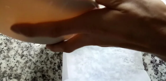 Cho chả cá vào giữa hai lớp giấy nến, tạo hình cho dễ chiên.