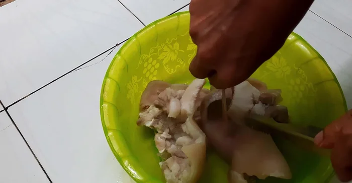 Ướp tai heo với tỏi, hành tím, ớt bầm, gói sốt ớt, bột ngọt, đường, nước tương. Trộn đều và để khoảng 30 phút cho thấm gia vị.