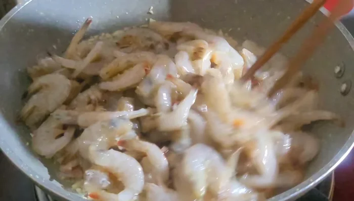 Cho tép vào chảo, để lửa lớn cho tép mau chuyển sang màu cam.