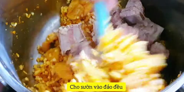 Cho củ đậu, sườn vào đảo đều, thêm mắm ruốc (hoặc nước mắm), 2 muỗng canh dầu màu điều.