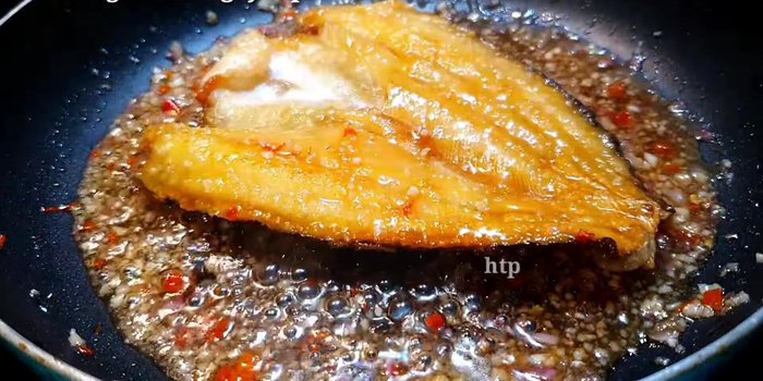 Cho cá dứa đã chiên vào chảo, đảo đều cho sốt phủ đều cá. Rim nhỏ lửa cho đến khi sốt sánh lại.