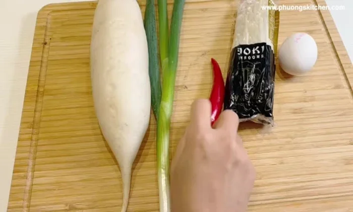 Đun sôi lại nước dùng, thêm rau củ mới (củ cải trắng, hành lá, ớt sừng, nấm kim châm).