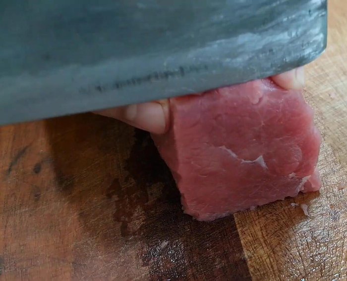 Cắt thịt bò thành từng miếng mỏng và vuông.