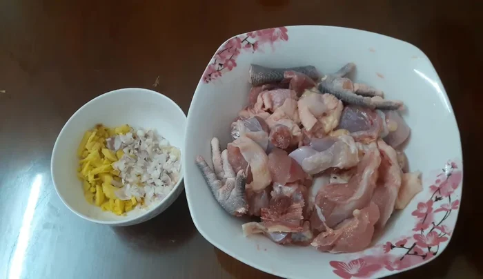 Ướp gà: Trộn gà với hạt nêm, muối, bột nghệ, và một nửa phần gừng đã băm nhỏ. Ướp khoảng 20 phút.