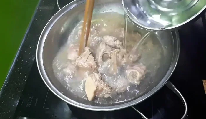 Đổ 2 lít nước (tùy lượng măng) vào nồi, thêm hành tím hoặc hành lá vào.
