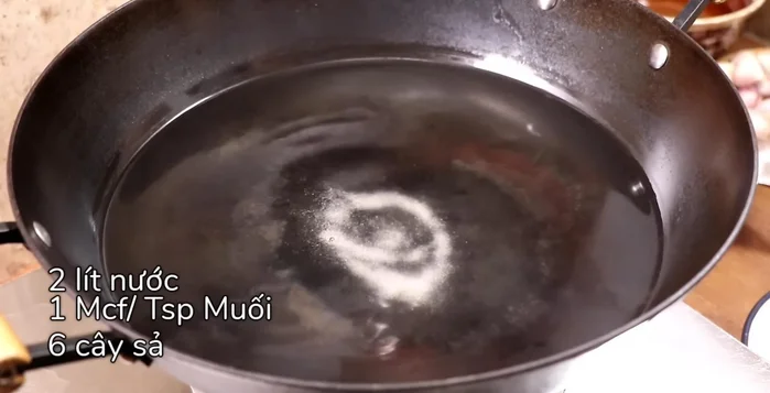 Nấu nước sôi với 2 lít nước, 1 muỗng cà phê muối, 6 cây sả đập dập, nước ngâm hành tây. Tắt bếp, cho mực vào ngâm 2 phút cho chín tới, vớt ra ngâm nước lạnh cho nguội.