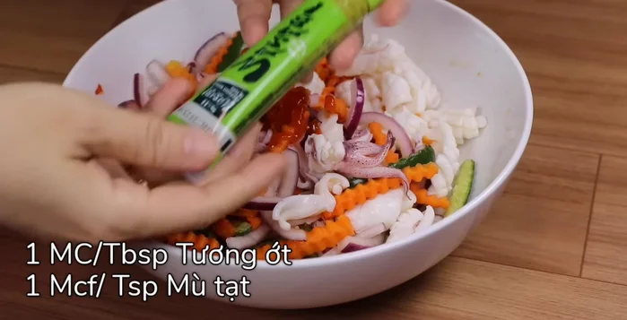 Thêm 1 muỗng canh tương ớt, 1 muỗng cà phê mù tạc, ớt băm nhuyễn, 3 muỗng canh sốt Thái, rau răm, húng lủi vào trộn đều.