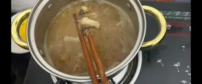 Cho sả, thơm, hành tây vào nước dùng đang sôi, đun khoảng 5-7 phút.