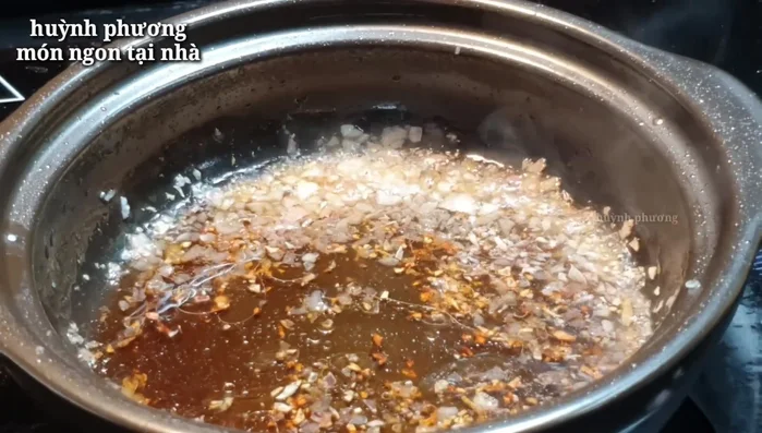 Thêm gia vị: Cho nước mắm chay, đường vào chảo hành tím, đảo đều.