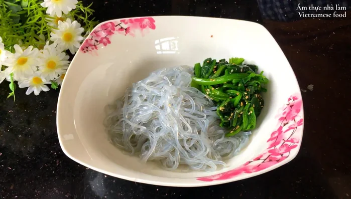 Trộn miến, cải bó xôi, cà rốt, ớt chuông, hành tây, trứng chiên, thịt bò trong tô. Chan nước sốt lên trên, thêm mè rang và trộn đều.