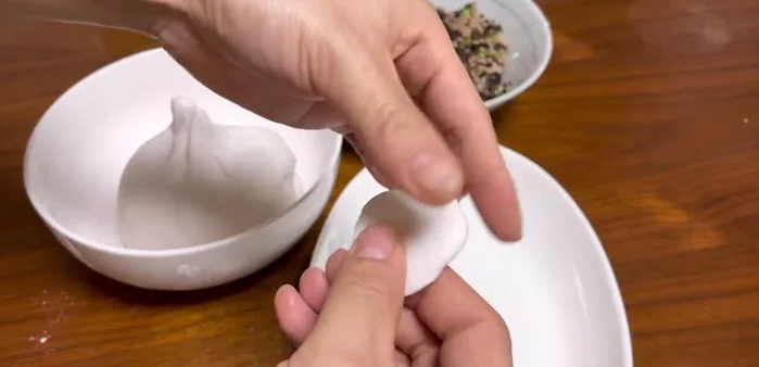 Cho bột năng vào khuôn, cho nhân vào giữa, gấp đôi khuôn lại (327.58)