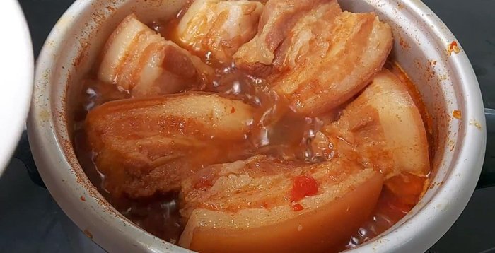 Cho trứng vào nồi thịt đang kho. Thêm 120ml nước mắm, 1/3 muỗng canh bột ngọt. Lược bỏ bớt xác ớt.