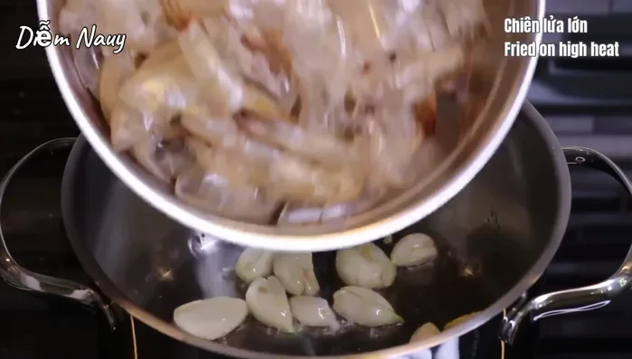 Cho vỏ và đầu tôm vào xào đến khi chuyển màu cam. (201.49)