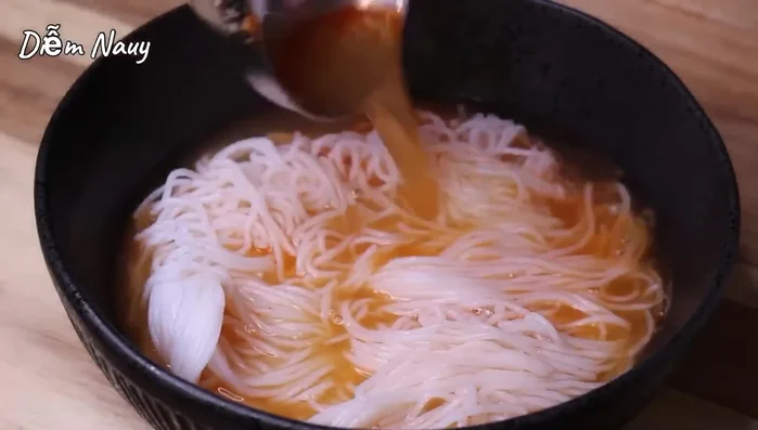 Trụng bún, cho bún vào tô, xếp suông lên trên, chan nước dùng và thưởng thức cùng rau sống, tóp mỡ. (569.99)