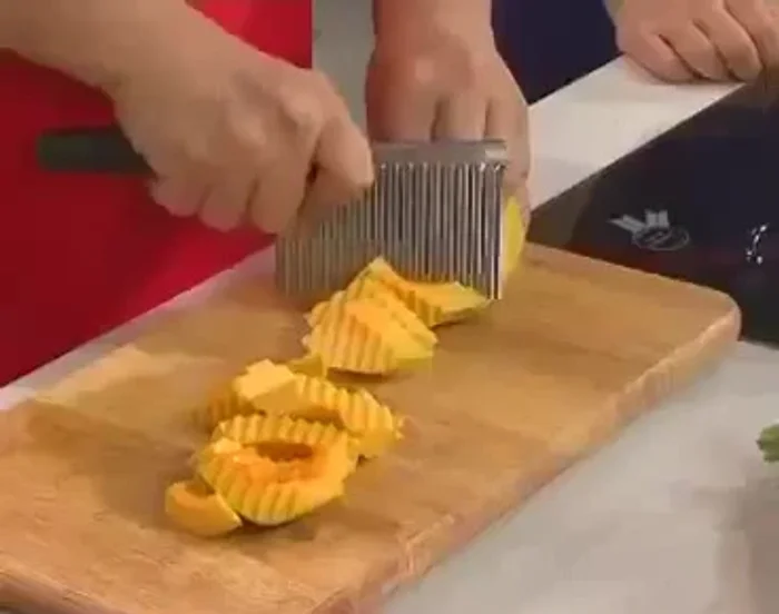 Cắt bí đỏ thành miếng vừa ăn bằng dao răng cưa.