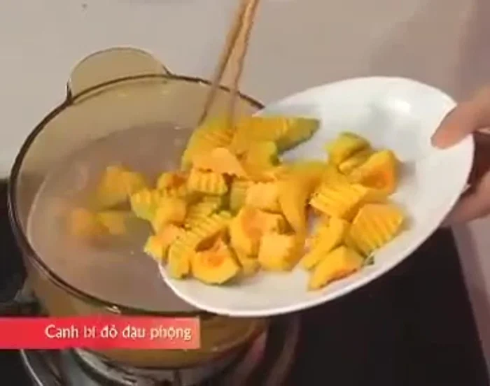 Cho bí đỏ vào, nấu thêm 10 phút, mở nắp để nước canh trong.