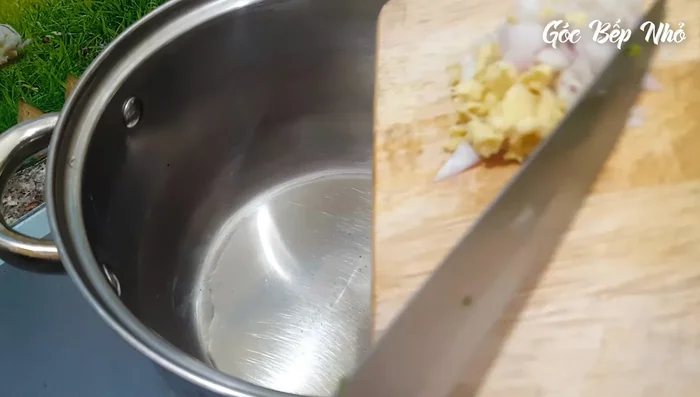 Cho 2 muỗng canh dầu ăn vào nồi, phi thơm hành tím và gừng.