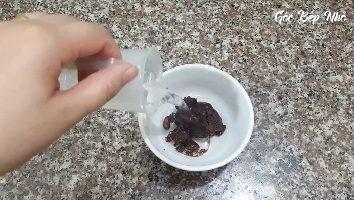 Rửa sạch ruột hàu, để ráo. Ngâm hàu với 60ml nước cốt me và 60ml nước sôi trong 10 phút cho me mềm.