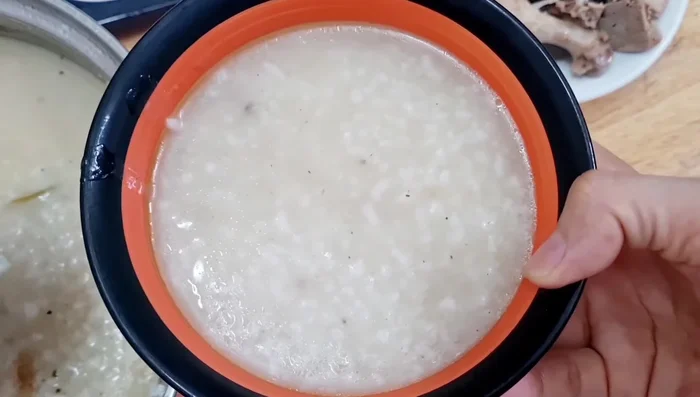 Múc cháo ra tô, cho thịt vịt, hành lá, rau răm, hành phi, lá chanh lên trên. Thêm tiêu, ớt tùy thích.