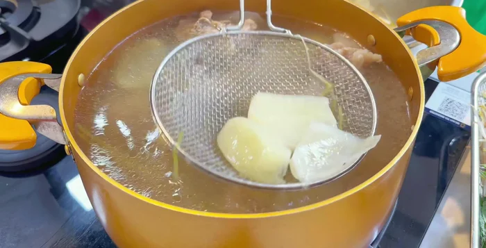 Nêm nếm lại gia vị (muối, hạt nêm, bột ngọt, đường) cho vừa khẩu vị. Thêm dầu điều để nước dùng đẹp mắt.