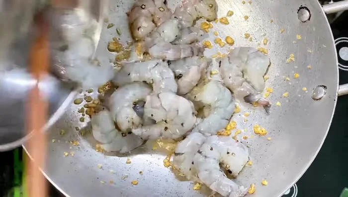 Cho tôm vào chảo, xào với lửa lớn cho tôm săn lại.