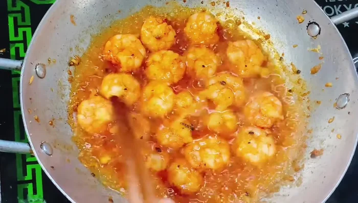 Lật mặt tôm để tôm thấm đều nước sốt.
