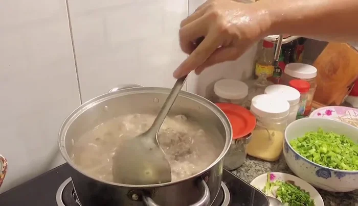 Múc cháo ra tô, trang trí với giá đỗ và cải.