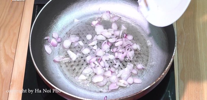 Cho cà chua xào vào nồi nước dùng.
