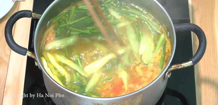 Cho dọc mùng vào nồi nước dùng.