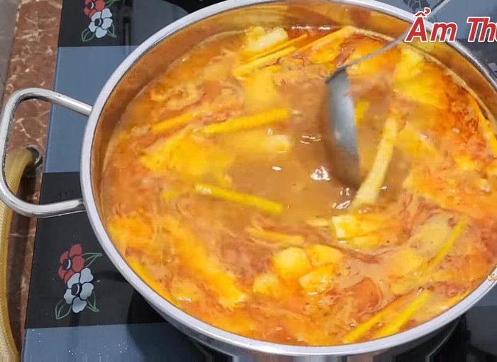 Nấu sôi, nêm nếm lại gia vị, thêm cà chua, ớt, lá chanh.
