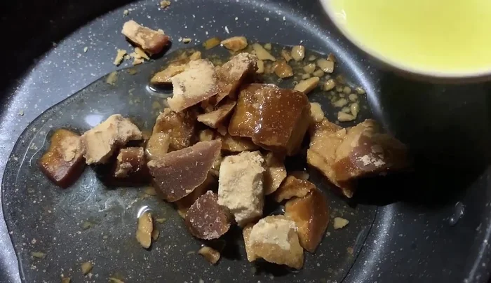 Thêm nước cốt gừng vào nồi đường.
