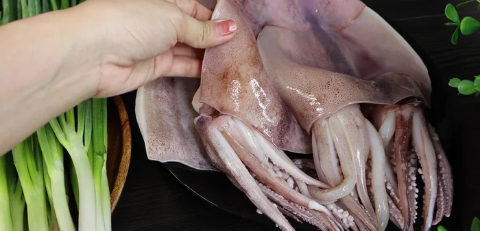 Sơ chế mực: Rửa sạch mực với gừng và muối. Lật phần thịt lên và khứa xéo, hơi nghiêng dao để mực bung ra khi hấp. Cắt mực thành từng miếng vừa ăn.