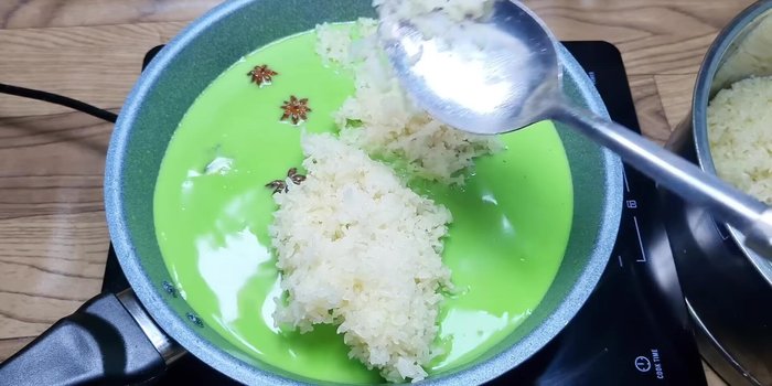 Cho nếp đã hấp vào hỗn hợp nước cốt dừa, dùng muỗng tán đều để nếp không bị vón cục. Đảo đều tay trên lửa nhỏ đến khi nếp rút hết nước và dẻo lại.