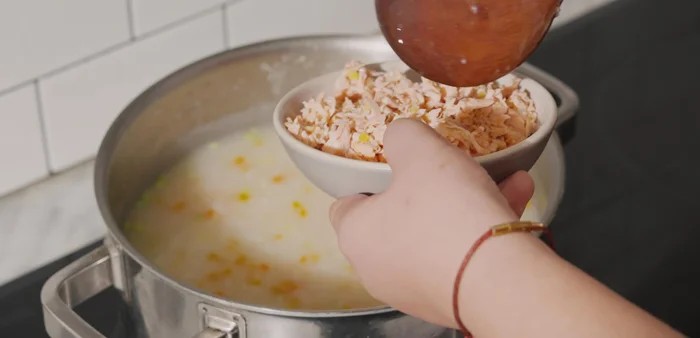 Hoàn thiện cháo: Cho cá hồi xào vào cháo, khuấy đều. Nêm nếm gia vị (bột canh, bột nêm, bột ngọt, nước mắm) cho vừa ăn. Thêm hành lá, đun thêm 1 phút, tắt bếp.