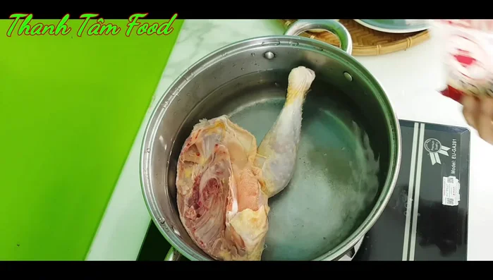 Làm sạch gà, ướp với muối, bột canh, gừng và luộc chín.