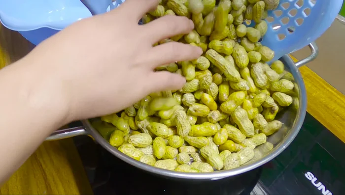 Cho lạc vào nồi inox. (113.88)