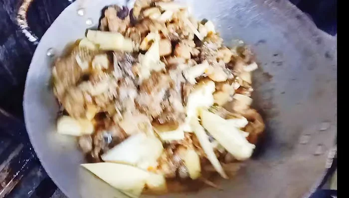 Thêm gia vị và rau: Thêm bột ngọt, bột nêm, lá lốt, tía tô vào nồi, trộn đều.