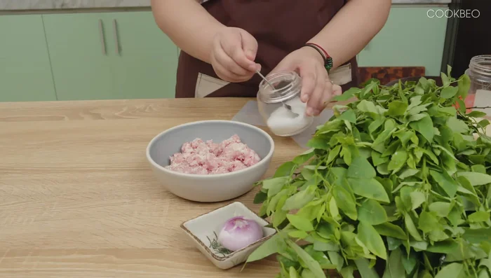Thịt lợn xay ướp cùng 1 thìa cà phê bột nêm, chút bột ngọt, chút dầu ăn. Trộn đều và để 10-15 phút cho thịt ngấm.