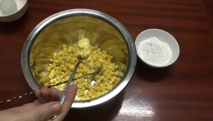 Trộn ngô với sữa đặc, bơ thực vật, lòng đỏ trứng, đường, trong khoảng 15 phút cho ngấm.