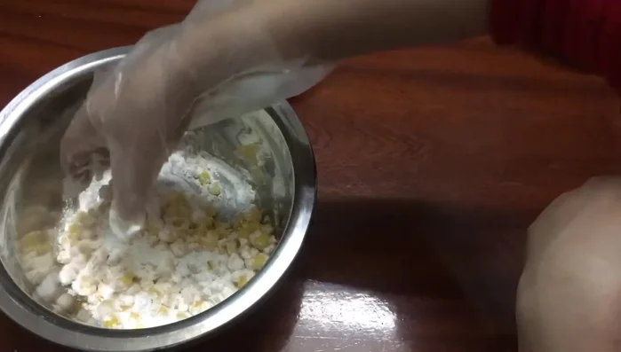 Trộn ngô với 50g bột chiên giòn, nhẹ tay để bột áo đều.