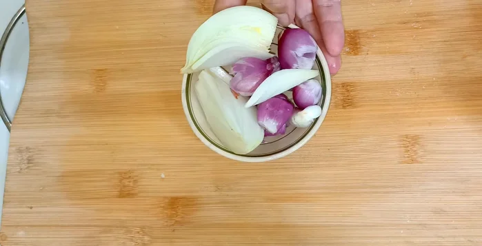 Dập dập hành tím, cho vào nồi nước dùng.
