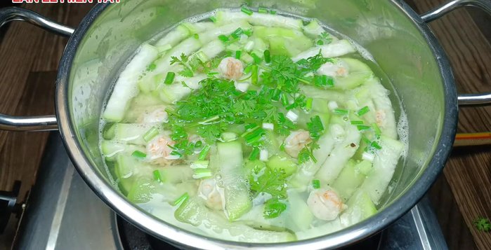 Hoàn thành: Tắt bếp. Cho hành lá, ngò rí và tiêu vào (399.28).