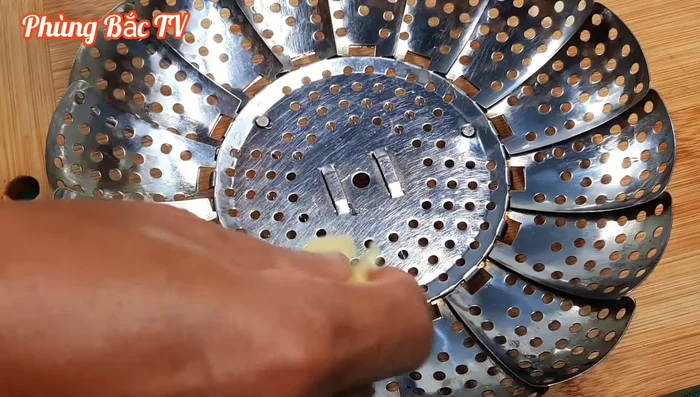 Lót sả vào xửng hấp, xếp mực lên trên.