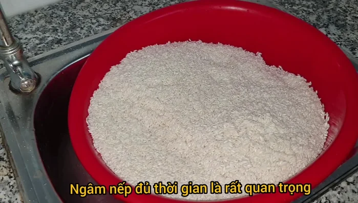 Ngâm gạo nếp với muối (3 muỗng canh cho 3kg gạo) từ 6-8 tiếng. (22.429)