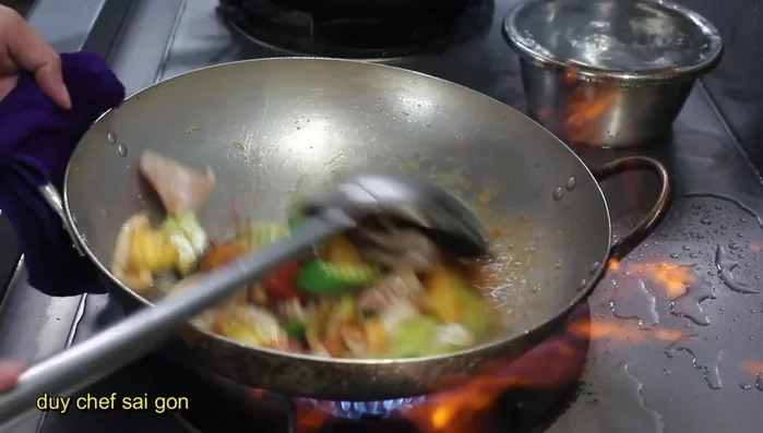 Thêm nước và xào đến khi mực gần chín.
