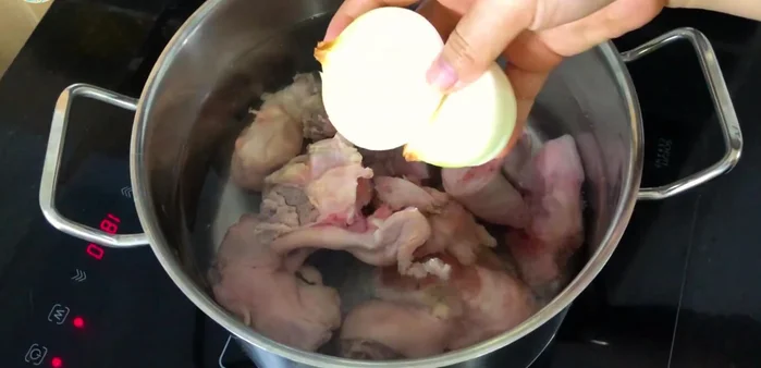 Cho 2.5 lít nước vào nồi, thêm chân giò heo đã sơ chế, 1 củ hành tây bổ đôi, 2 muỗng cà phê hạt nêm, 1 muỗng cà phê muối, 3 muỗng cà phê bột ngọt. Đun sôi rồi ninh trong khoảng 30 phút.