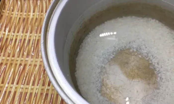 Cắm điện nấu cháo. Canh cháo không bị trào bằng cách để một chiếc đũa lên miệng nồi.